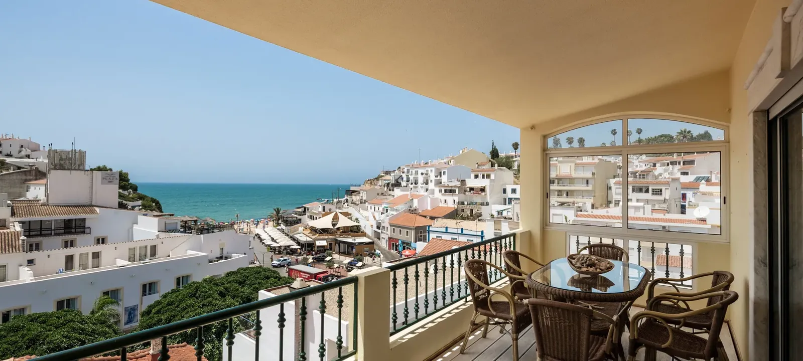 Balkon met uitzicht over een wit kustdorp en het strand in de Algarve