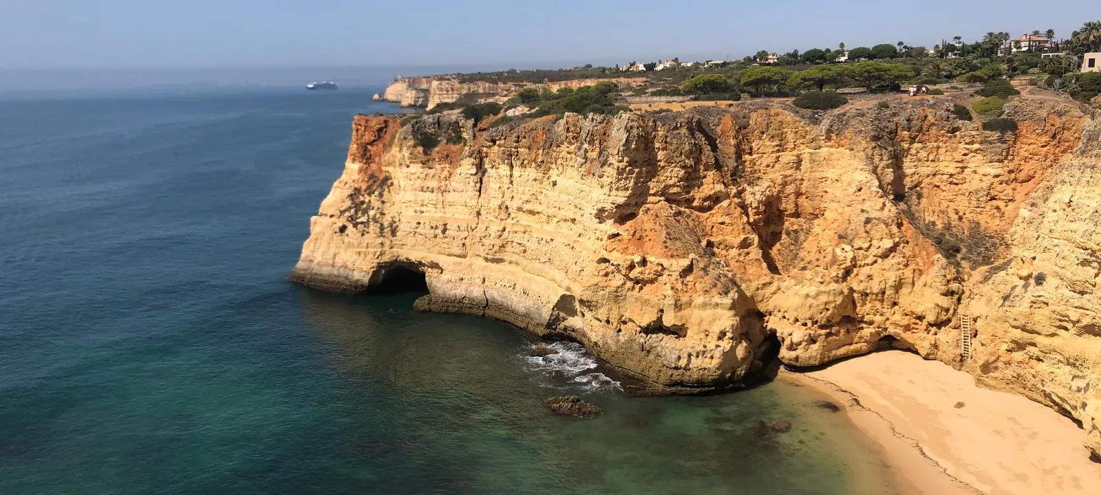 Breed strand onder okerkleurige kliffen bij Praia da Rocha, Portimão, Algarve
